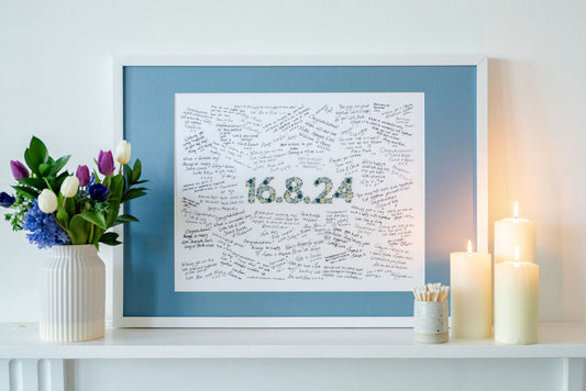 A Floral Collection Mr & Missive wedding guest book alternative on a mantlepiece with fresh flowers and lit candles