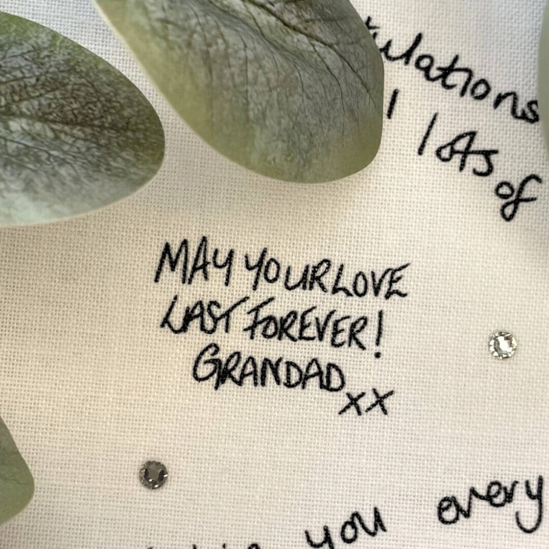 Close up of a printed handwritten message on a Mr & Missive wedding guest book alternative with Swarovski crystal details.