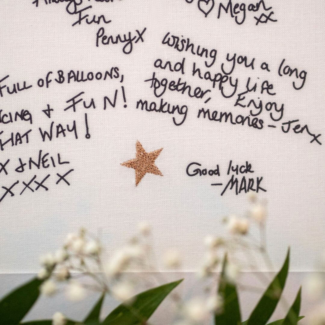 Close up of printed handwritten messages on a Mr & Missive wedding guest book alternative with gold stitched details.