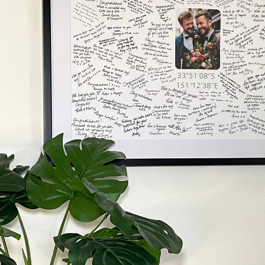 A handwritten Mr & Missive wedding guest book alternative from the Portrait Collection featuring a photograph centrepiece and a plant in the foreground.