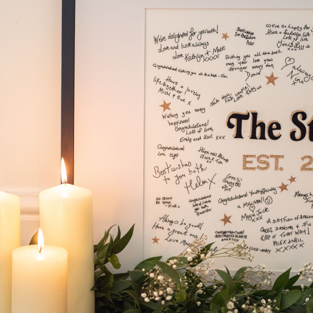 A close up of the black velvet centrepiece with gold accents from the Mr & Missive Signature Collection wedding guest book alternative, with candles in the foreground. 