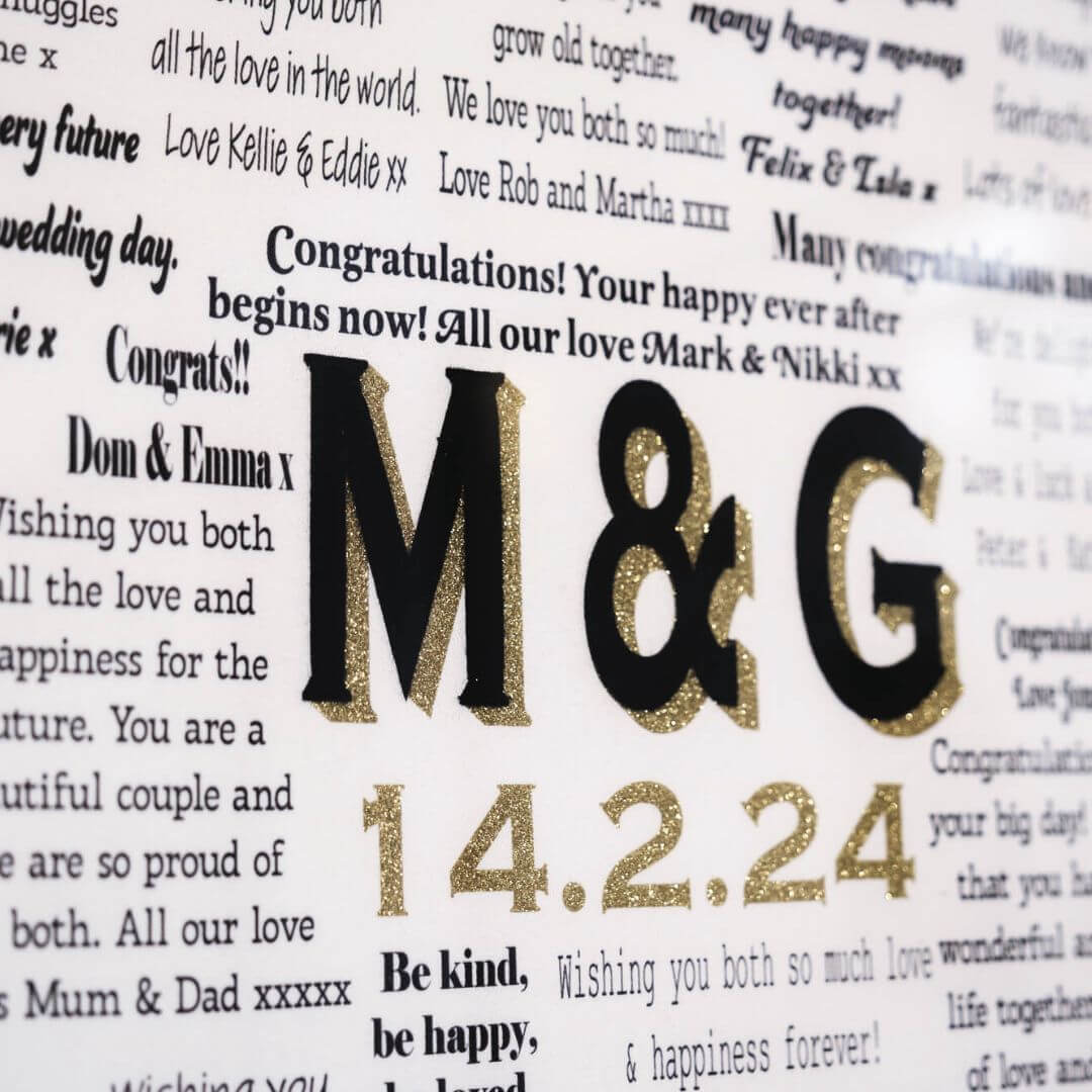Close up of a Typed Collection Mr & Missive wedding guest book alternative with black velvet centrepiece and gold shadow font and date.